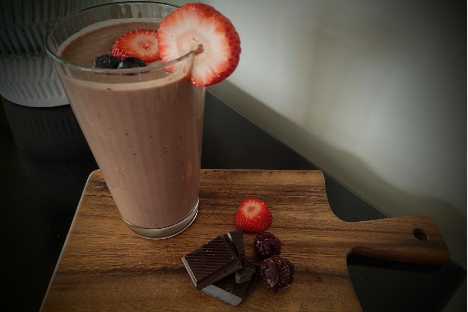 Healthy smoothie with dark chocolate, plant based protein powder and frozen berries