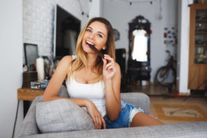 Woman enjoying chocolate - you can still indulge in your guilty pleasures and get fit.