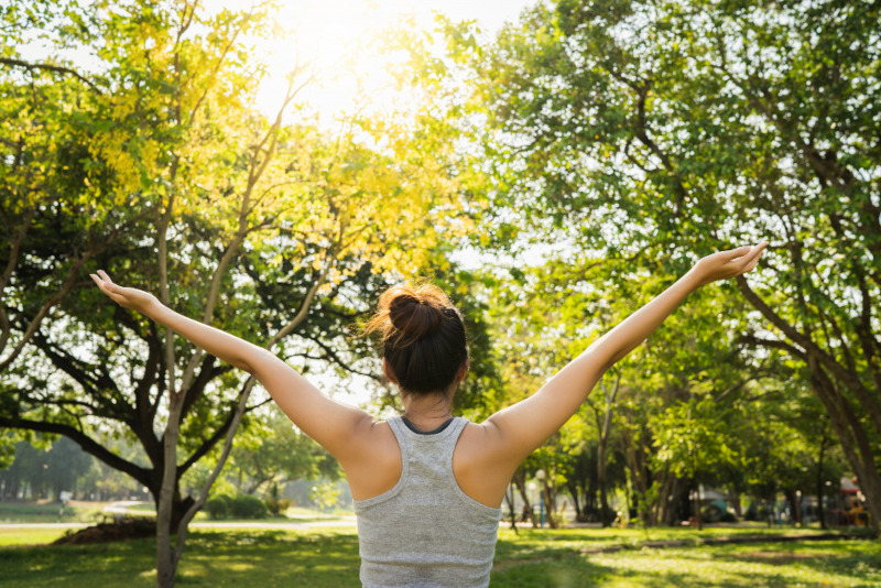Woman celebrating victory outside in a park - and by giving in to your cravings you can life healthy too