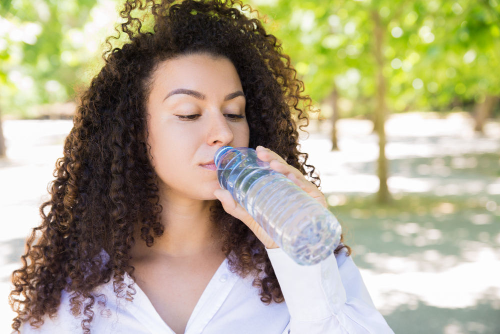 woman drinking water - demonstrates the importance of water in weight loss nutrition